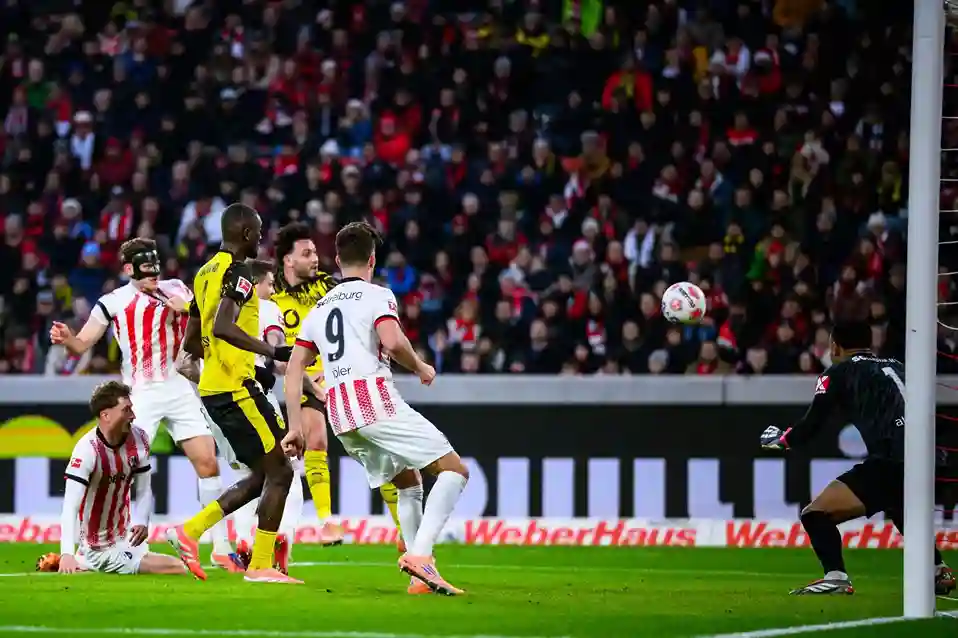 freiburg-dortmund-bundesliga-14-dezember-2025 Freiburg vs Borussia Dortmund Bundesliga-Spiel 14. Dezember 2025, Spieler im Duell um den Ball